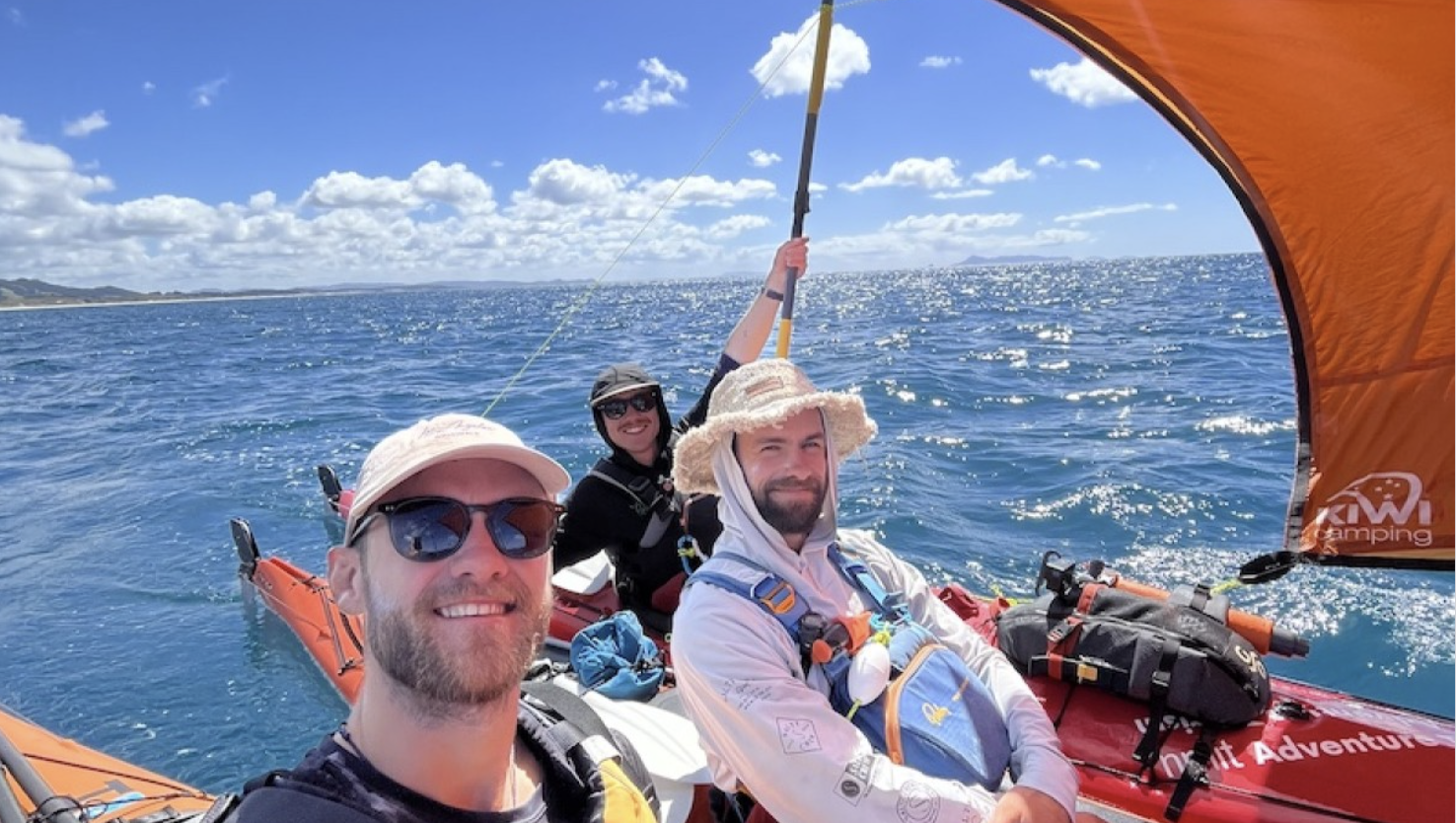 Selfie of three men in a kayak on the water on a beautiful sunny day.